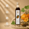 A bottle of Kaizer pumpkin seed oil stands on a wooden board with pumpkins, leaves, and a bowl of pumpkin seeds around it. Text on the left highlights product benefits: 100% cold-pressed, traditionally extracted, lab tested, and everyday cooking oil.
