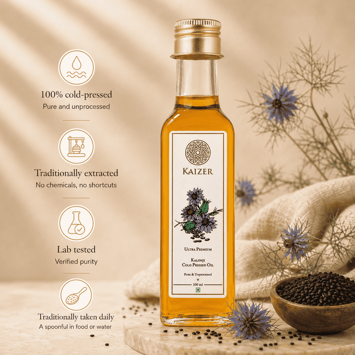 A bottle of Kaizer Kalonji Oil (black seed oil) centered on a styled background with text callouts on the left, dried flowers, a wooden bowl of black seeds, and a beige fabric cloth.