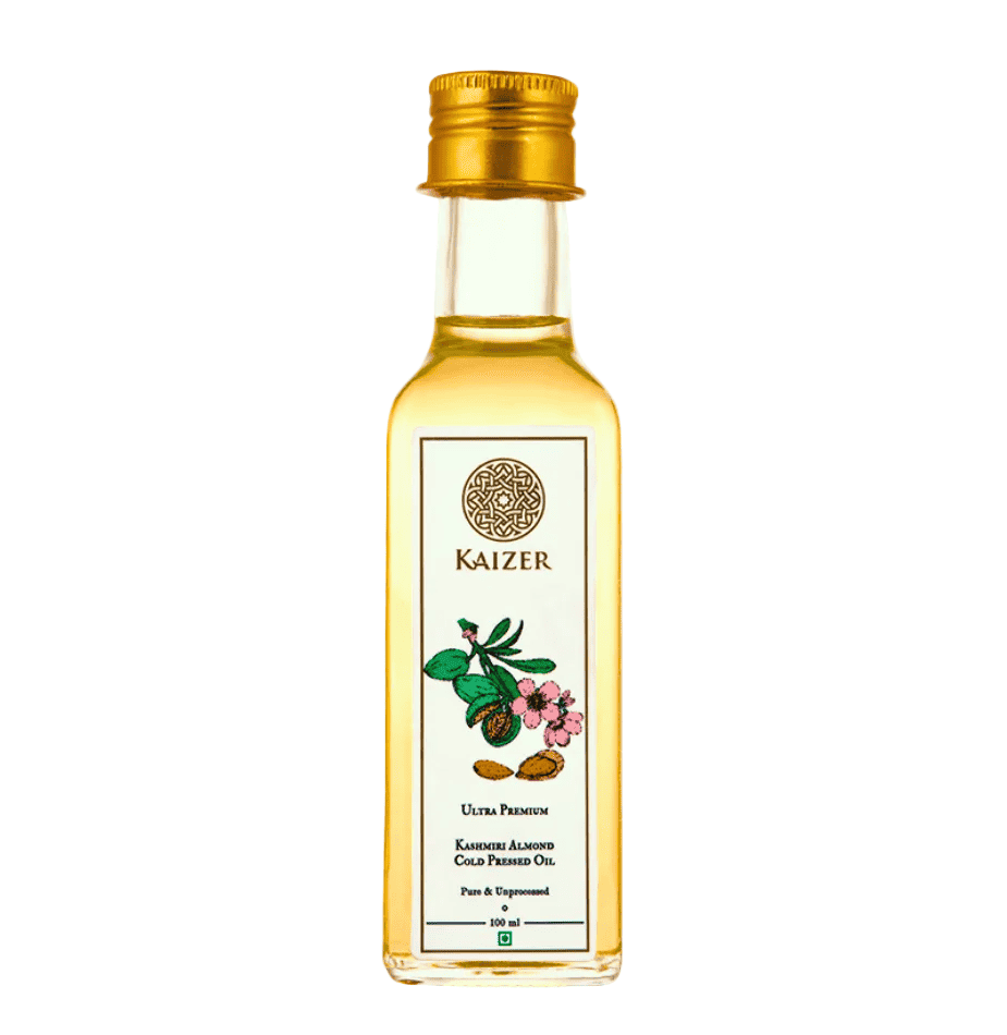 A clear glass bottle filled with almond oil, labeled 'Kaizer Kashmiri Almond Oil' with additional text and an illustration of almonds.